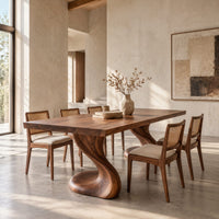 Dining table with two sculpted pedestal legs and a thick flat top in a bright open plan dining room