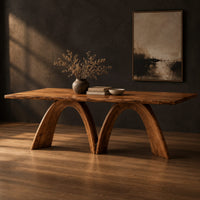 Dining table with twin sculpted arch legs and a smooth slab top, three-quarter view showing the grain
