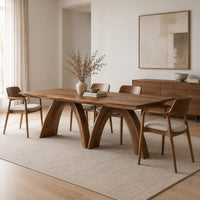 Dining table with twin sculpted arch legs and a smooth slab top in a Scandinavian dining room with white walls