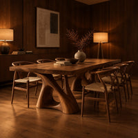 Dining table with a thick plank top on two sculpted loop pedestals in an evening dining room with walnut wall paneling