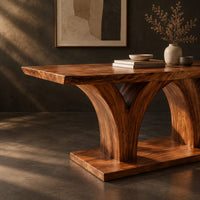 Corner detail of rectangular dining table with two flared pedestals on a shared low plinth beside wood, brass and linen samples