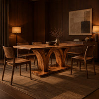 Rectangular dining table with two flared pedestals on a shared low plinth in an evening dining room with walnut wall paneling
