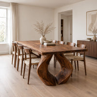 Rectangular dining table on two sculpted legs that form a teardrop gap in a Scandinavian dining room with white walls