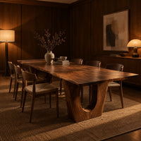 Long dining table on two heavy pedestals with arched openings in an evening dining room with walnut wall paneling