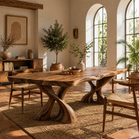 Dining table with two twisted pedestals and a live edge top in a bright dining room with arched windows and plants