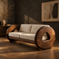 Sofa with thick circular wooden arms, hollow cutouts and cream seat cushions, three-quarter view showing the grain