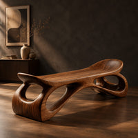 Bench with a dished seat and sculpted legs with oval cutouts, three-quarter view showing the grain