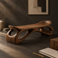 Corner detail of bench with a dished seat and sculpted legs with oval cutouts beside wood, brass and linen samples
