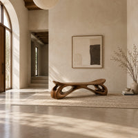 Bench with a dished seat and sculpted legs with oval cutouts in a bright open plan entryway