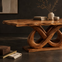 Corner detail of dining table with a wavy edged slab top and a double infinity loop base beside wood, brass and linen samples