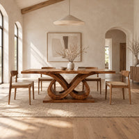 Dining table with a wavy edged slab top and a double infinity loop base in a bright open plan dining room