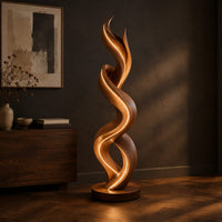 Twisting double ribbon floor lamp with a warm glow, three-quarter view showing the grain