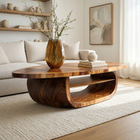 Oval coffee table on a drum base with an open shelf in a bright modern living room
