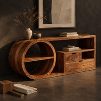 Corner detail of console table with a drum shaped shelf end, two drawers and an open cubby beside wood, brass and linen samples