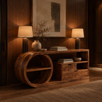 Console table with a drum shaped shelf end, two drawers and an open cubby in an evening entryway with walnut wall paneling