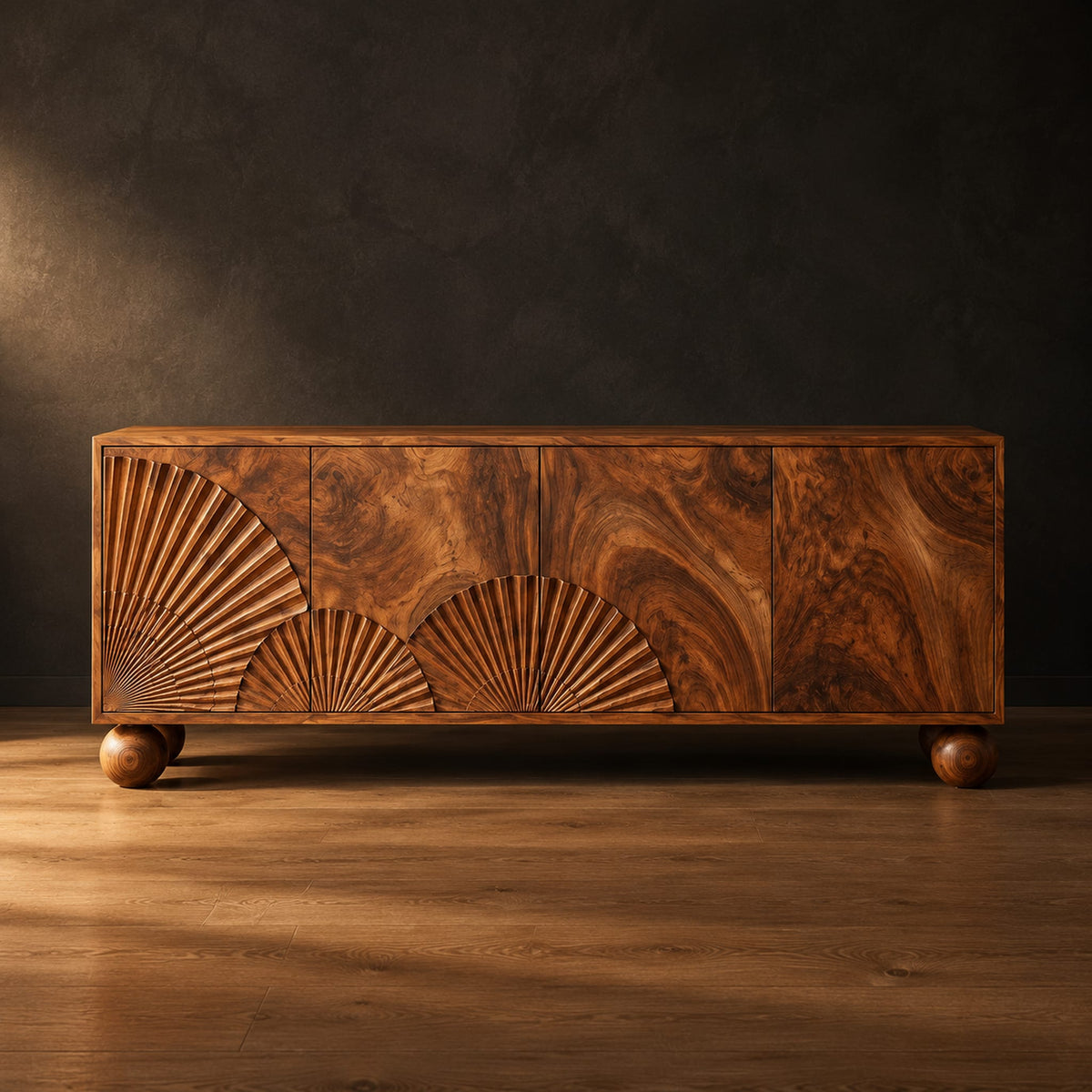 Wooden sideboard with fan carved relief on four door fronts and ball feet in a dark studio against a charcoal plaster wall