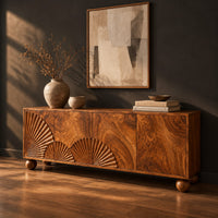 Wooden sideboard with fan carved relief on four door fronts and ball feet, three-quarter view showing the grain