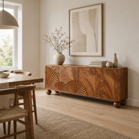 Wooden sideboard with fan carved relief on four door fronts and ball feet in a Scandinavian dining room with white walls