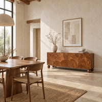 Wooden sideboard with fan carved relief on four door fronts and ball feet in a bright open plan dining room