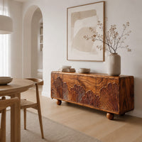 Sideboard carved with fan shaped leaves on four doors and ball feet in a Scandinavian dining room with white walls