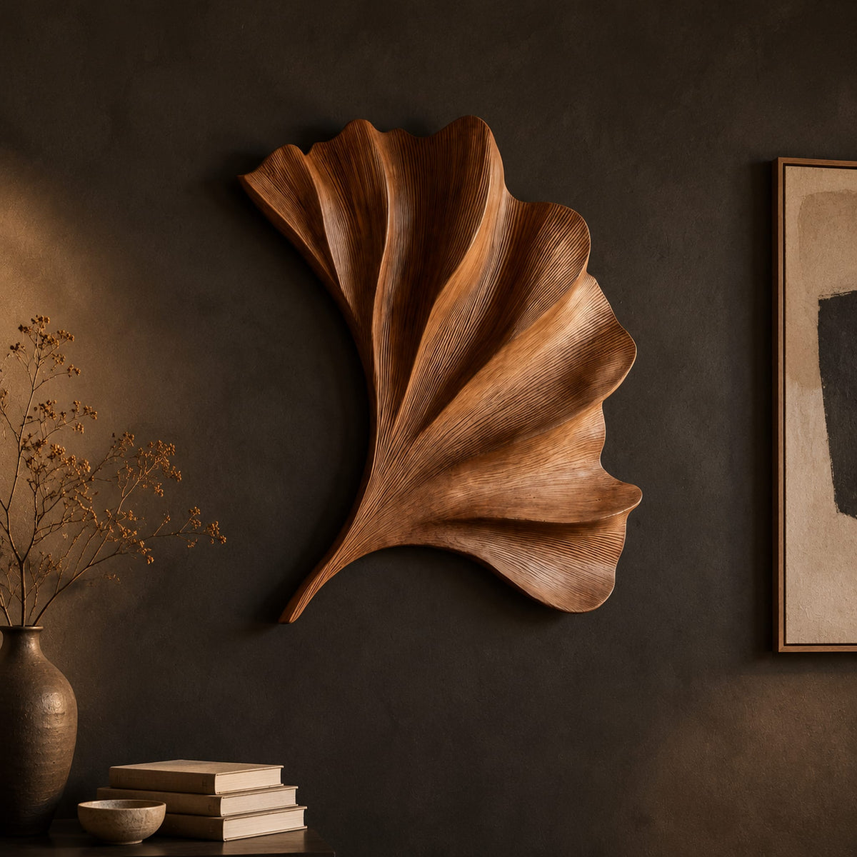 Fan shaped carved leaf wall art with radiating ribs and a curved stem on a dark charcoal plaster wall