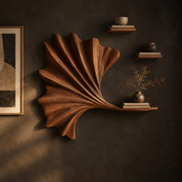 Fan shaped leaf wall art with carved ribs and a small ledge on a dark charcoal plaster wall