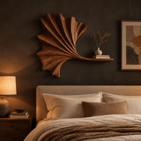 Fan shaped leaf wall art with carved ribs and a small ledge above a bed in a dusk lit bedroom