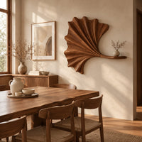 Fan shaped leaf wall art with carved ribs and a small ledge beside a dining table in natural light