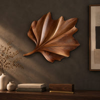 Detail of fan shaped wooden leaf with raised ribs and a ruffled edge beside wood, brass and linen samples