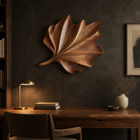 Fan shaped wooden leaf with raised ribs and a ruffled edge above a desk in a dark study corner