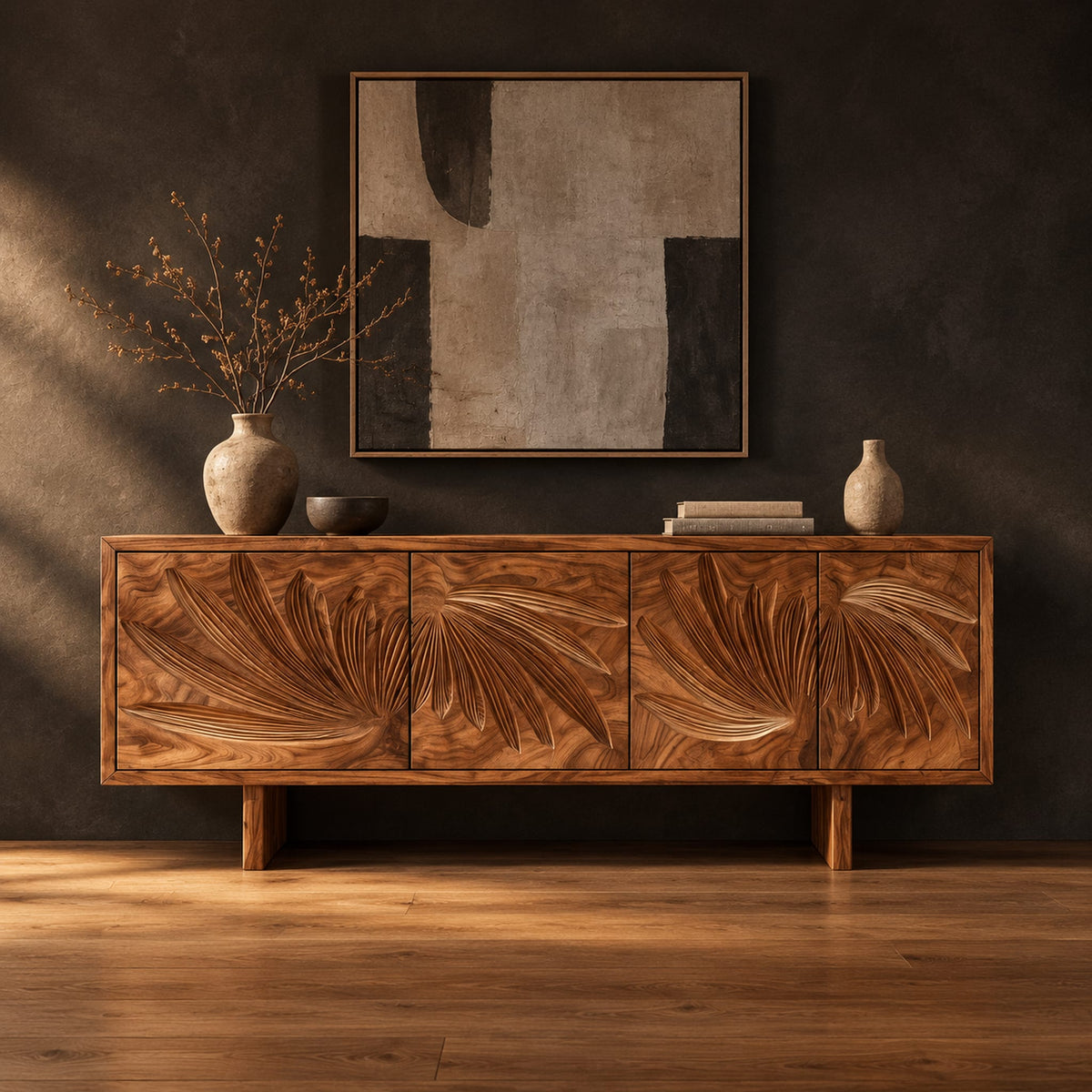 Sideboard with four doors carved with fanned fronds on two block legs in a dark studio against a charcoal plaster wall