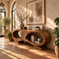 Console table shaped like a figure eight with two oval openings in a bright entryway with arched windows and plants