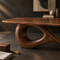 Corner detail of dining table with a flowing figure eight loop base beside wood, brass and linen samples