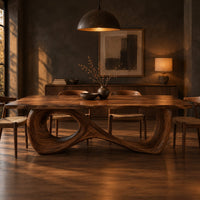 Dining table with a flowing figure eight loop base in a dark dining room at golden hour