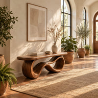 Bench with a smooth flat seat on a figure eight loop base in a bright entryway with arched windows and plants