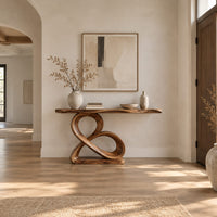 Console table with a figure eight wooden pedestal and a narrow natural edge top in a bright open plan entryway