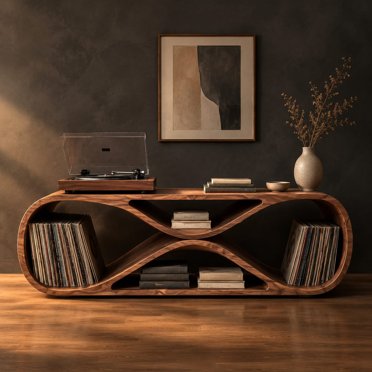 Low record console shaped like a figure eight with open bays at each end in a dark studio against a charcoal plaster wall