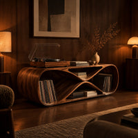 Low record console shaped like a figure eight with open bays at each end in an evening living room with walnut wall paneling