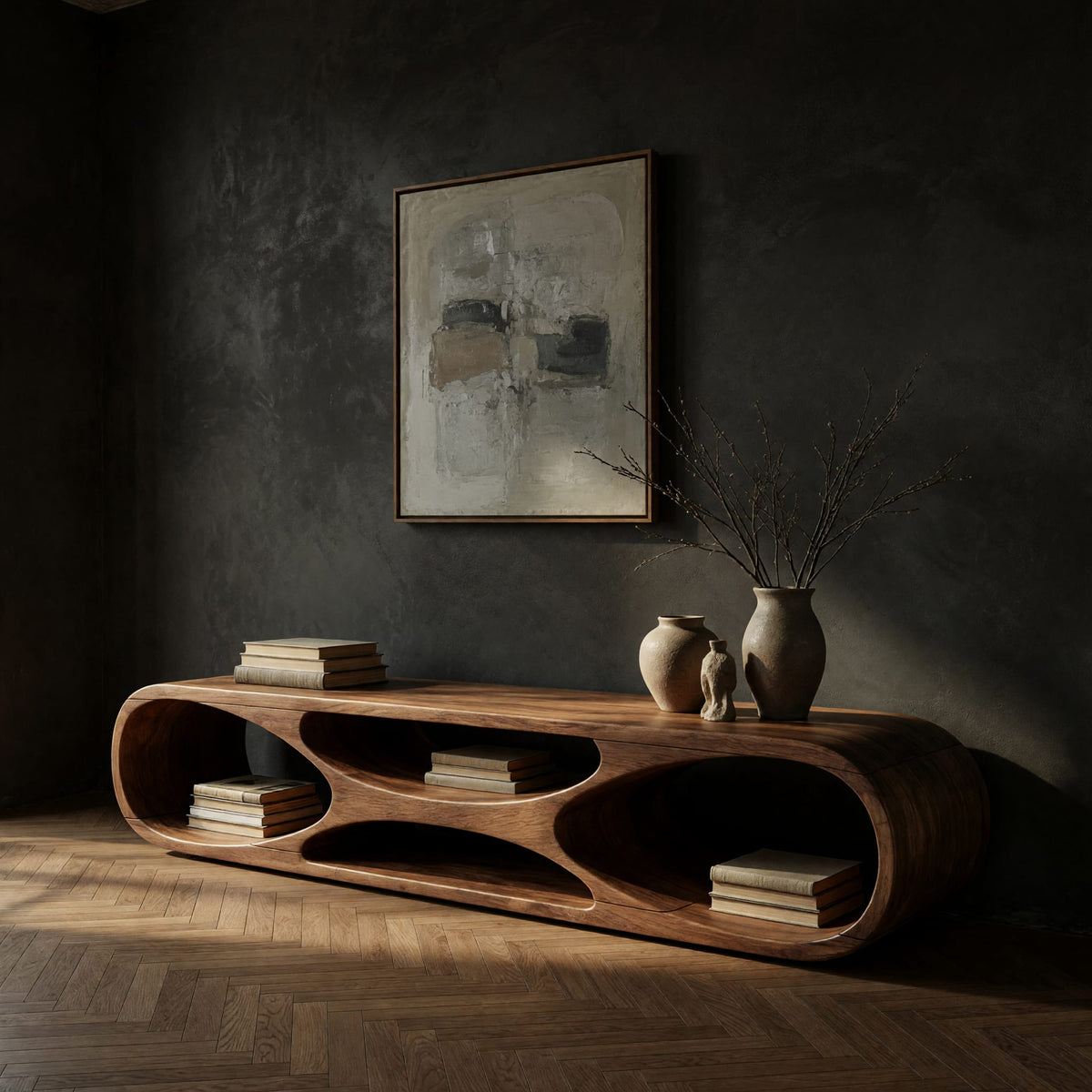 Low loop TV stand with carved figure eight openings in a dark studio against a charcoal wall