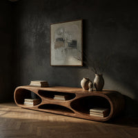 Low loop TV stand with carved figure eight openings in a dark studio against a charcoal wall