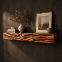 Thick mantel beam with a carved wave pattern along the front, three-quarter view showing the grain