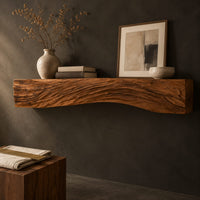 Corner detail of fireplace mantel with carved flowing grain ridges and a wavy lower edge beside wood, brass and linen samples