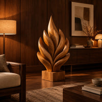 Flame shaped sculpture of layered carved leaves on a square wooden base in an evening living room with walnut wall paneling