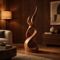 Flame shaped wood sculpture with two pointed tips and a swirling base in an evening living room with walnut wall paneling