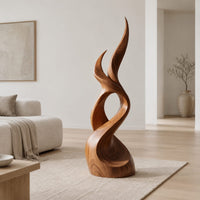 Flame shaped wood sculpture with two pointed tips and a swirling base in a Scandinavian living room with white walls
