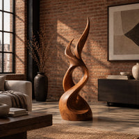 Flame shaped wood sculpture with two pointed tips and a swirling base in an industrial loft living room with exposed brick