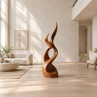 Flame shaped wood sculpture with two pointed tips and a swirling base in a bright open plan living room