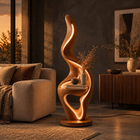 Flame shaped floor lamp with a glowing edge and a small shelf in a dark living room at golden hour