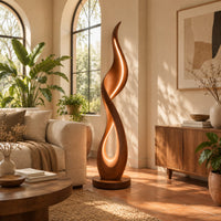 Flame shaped floor lamp with a glowing teardrop opening on a disc base in a bright living room with arched windows and plants