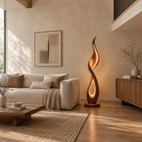 Flame shaped floor lamp with a glowing teardrop opening on a disc base in a bright open plan living room